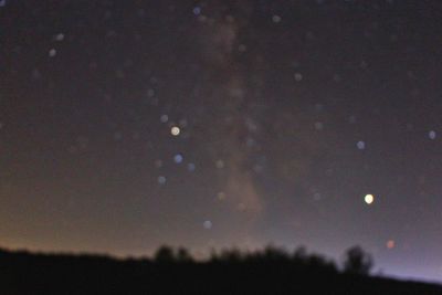 Scenic view of silhouette field against sky at night