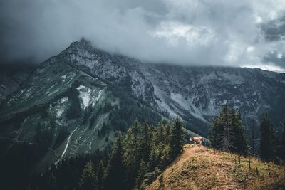 Scenic view of snowcapped mountains against cloudy sky