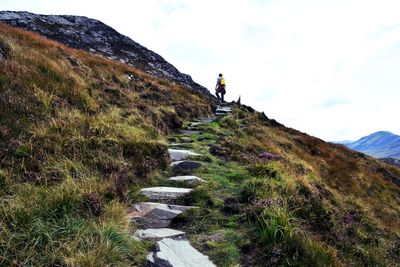 Low angle view of male hiker standing on mountain