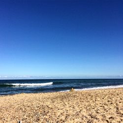 Scenic view of beach against clear blue sky