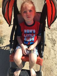 Portrait of cute boy sitting outdoors