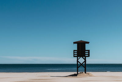 Lifeguard hut on beach against clear sky