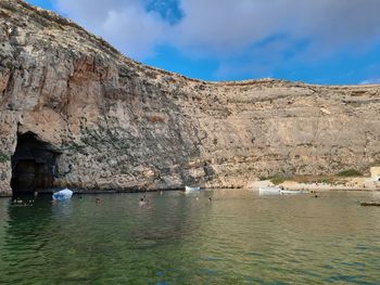 Rock formations by sea against sky