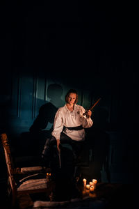 Man sitting on seat in the dark