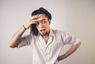 Portrait of young man standing against white background