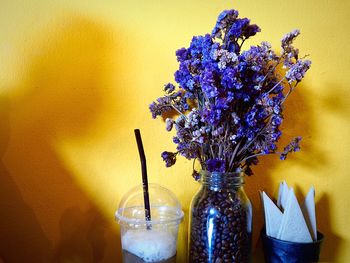 Close-up of flower vase on table against wall