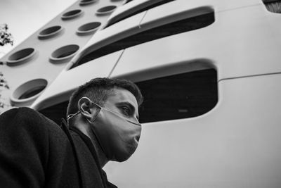 Low angle view of man wearing mask against building