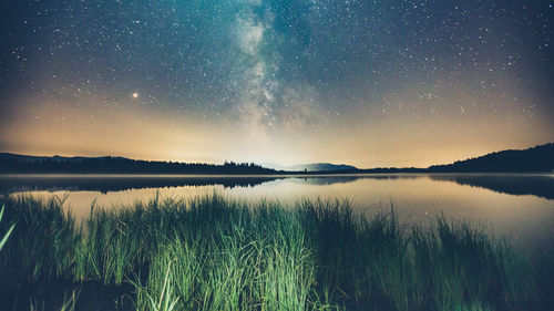 Scenic view of lake against sky at night