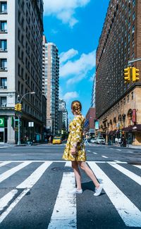 Woman walking on zebra crossing in city