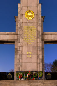 Text on wall in city against clear sky