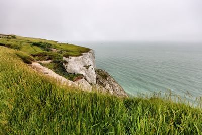 Scenic view of white cliffs of dover and sea against sky