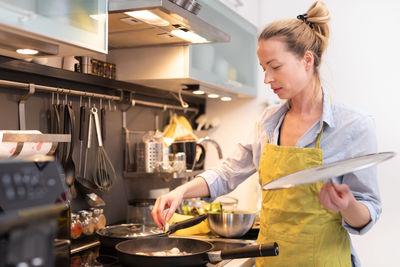 Woman working on table at kitchen