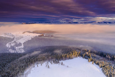 Scenic view of snow covered landscape against sky during sunset