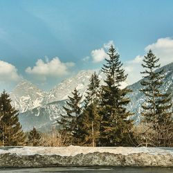 Scenic view of snow covered mountains against blue sky