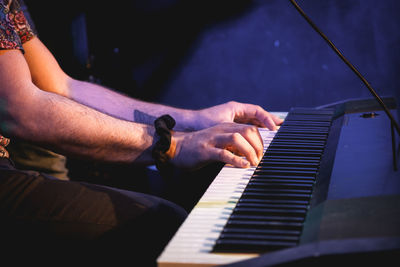 Midsection of man playing piano