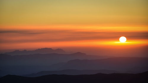 Scenic view of silhouette mountains against romantic sky at sunset