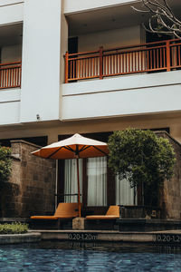 Cozy summer veranda with a sunbed and an umbrella near the pool