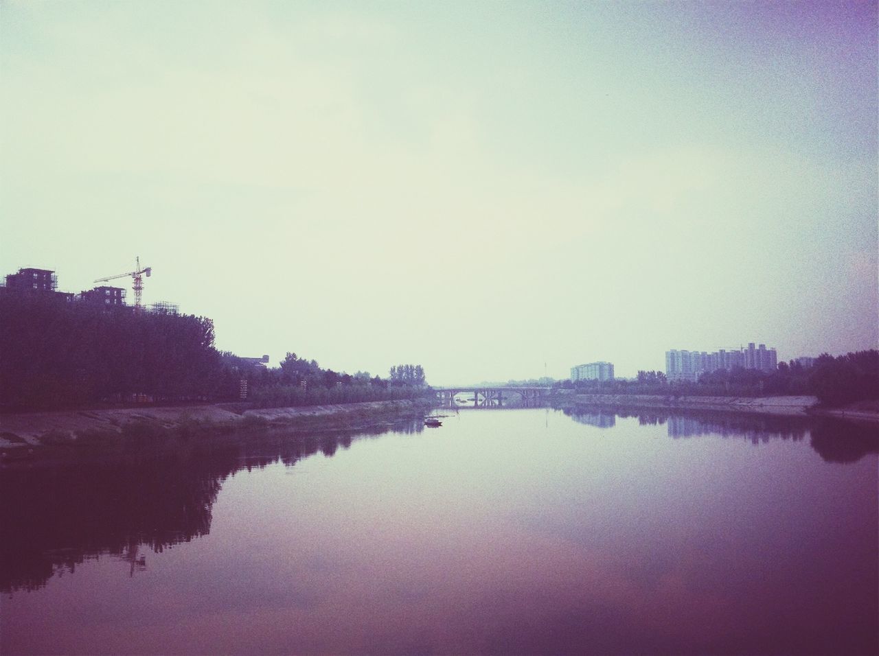 water, reflection, waterfront, lake, sunset, tranquility, copy space, tranquil scene, sky, built structure, river, architecture, silhouette, scenics, clear sky, building exterior, beauty in nature, nature, calm, standing water