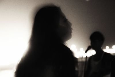 Rear view of man and woman standing against blurred background