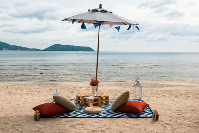 Beach picnic to drink and eat and enjoy seascape view in evening at beach in phuket, thailand.