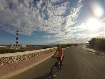 Woman riding bicycle on road in city