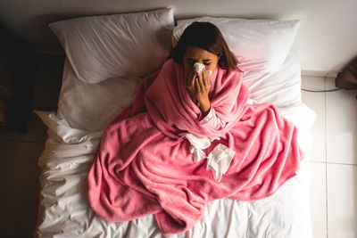 High angle view of woman relaxing on bed at home