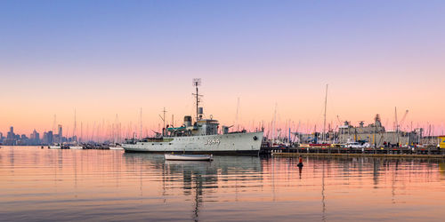 Sailboats in sea at sunset