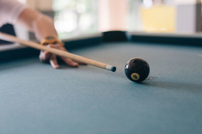Cropped hand of person playing snooker