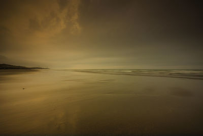 Scenic view of beach against sky during sunset