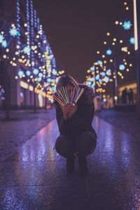 Woman holding colorful equipment at night