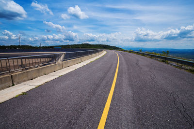 Empty road against cloudy sky