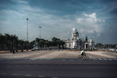 Bicycle parked on road against sky in city