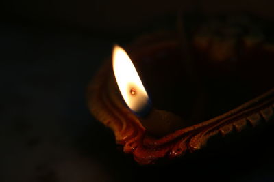 Close-up of lit candle in dark room