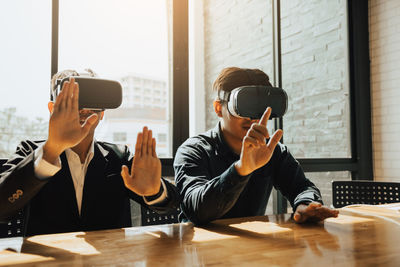 Businessmen wearing virtual reality simulator in office