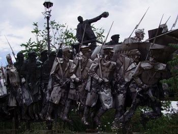 Low angle view of figurine against sky