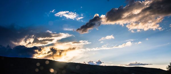 Scenic shot of silhouette mountains against blue sky
