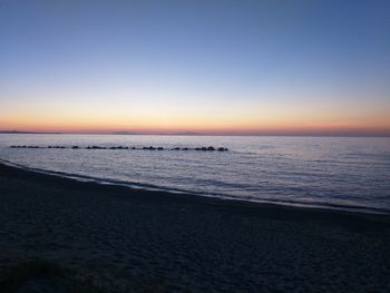 Scenic view of sea against clear sky at sunset