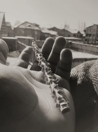 Close-up of person holding hands against sky