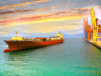 Nautical vessel on sea against sky during sunset