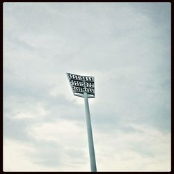 Low angle view of road sign against cloudy sky