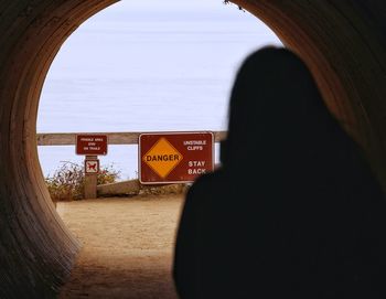 Silhouette of woman in tunnel at the beach