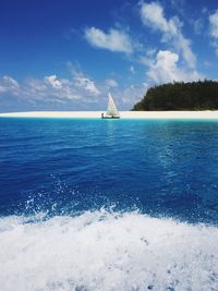 Mid distance view of sailboat in sea against sky