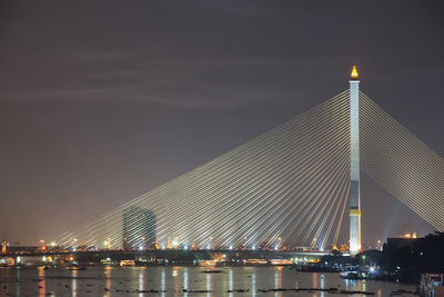 View of suspension bridge in city at night