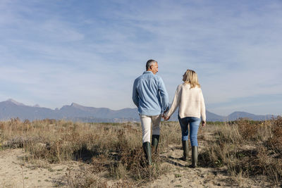 Couple talking to each other walking at dunes