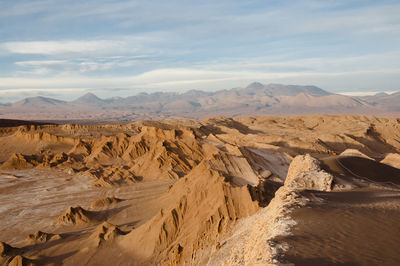 Scenic view of desert against cloudy sky