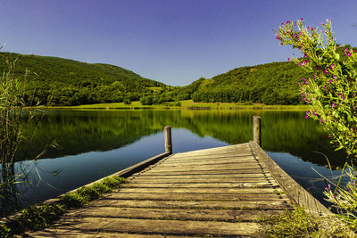 Scenic view of lake against clear blue sky