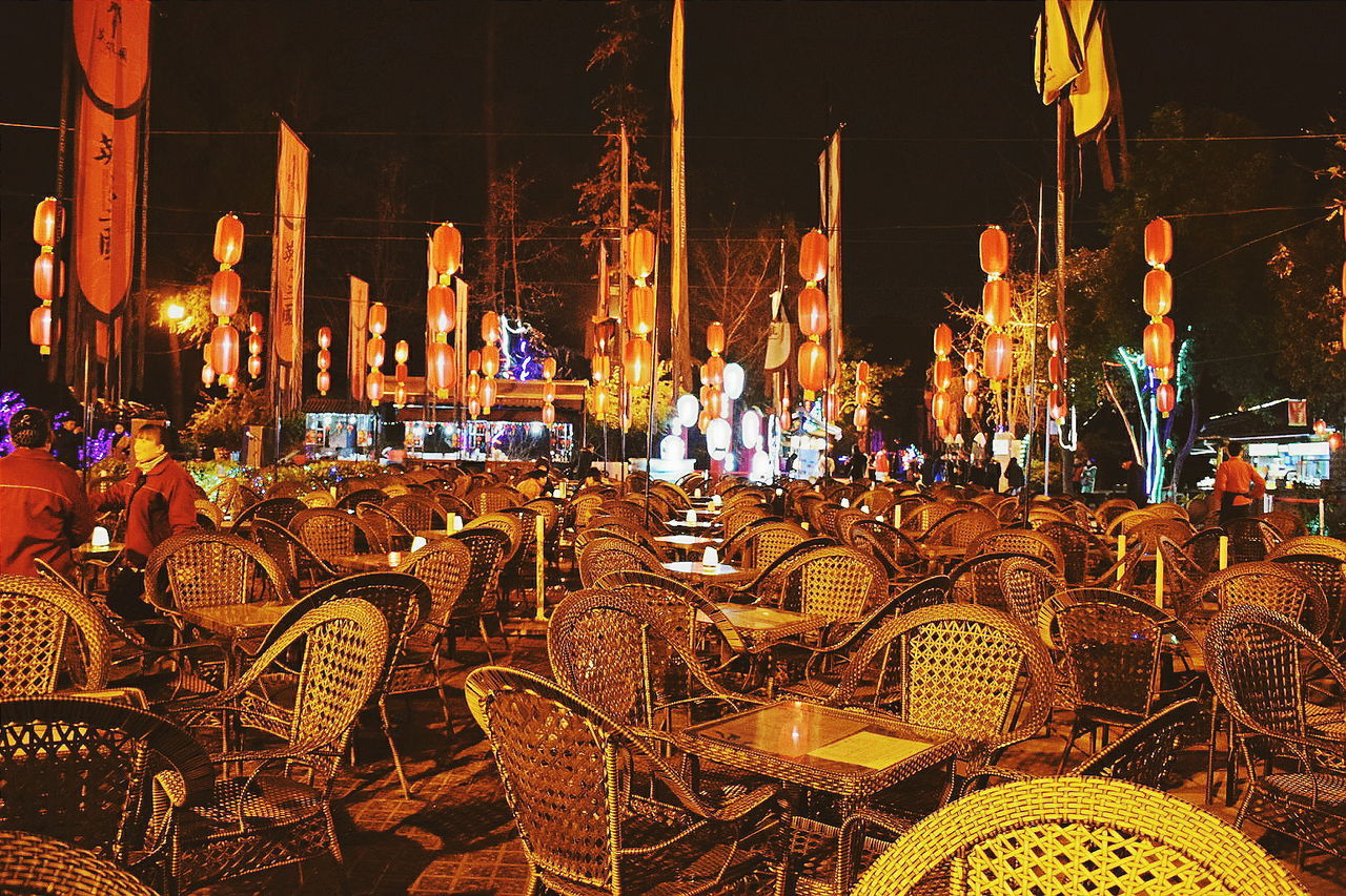 chair, night, table, large group of objects, outdoors, illuminated, arrangement, no people, place setting