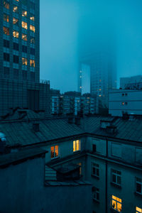 Illuminated buildings against sky at dusk