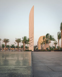 Palm trees and buildings against sky during sunset