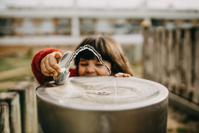 Cute child playing with park drinking fountain